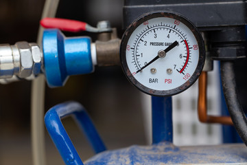 Pressure gauge of air compressure setup on blue tank with coupler