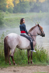 Young woman on a white horse looking into the distance
