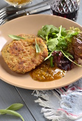Fried pork chop with fresh herbs and fruit sauce, vertical