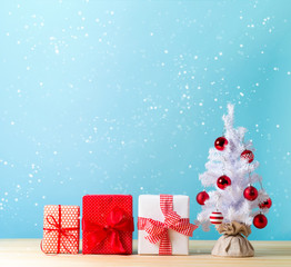 White Christmas tree and gift boxes in a snowy day