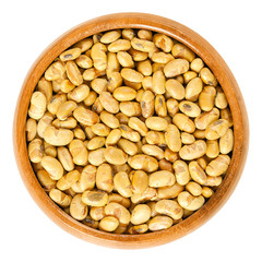 Roasted soybeans in wooden bowl. Dried, yellow soya beans, crispy roasted and slightly salted, used...