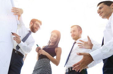 business man showing something on a whiteboard to his colleagues