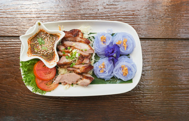 Thai style food, grilled pork with purple noodles and spicy dipping sauce.