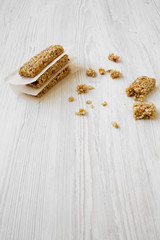 Granola bars on baking sheet on a white wooden surface, side view. Copy space.