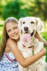 Little girl with golden retriever dog in the park