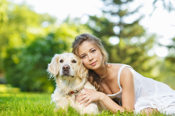 Young woman with golden retriever dog in the summer park