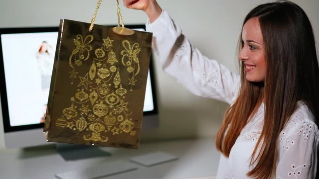 Attractive woman making shopping online at home. Pretty shopaholic female receiving her purchase made online on clothes website
