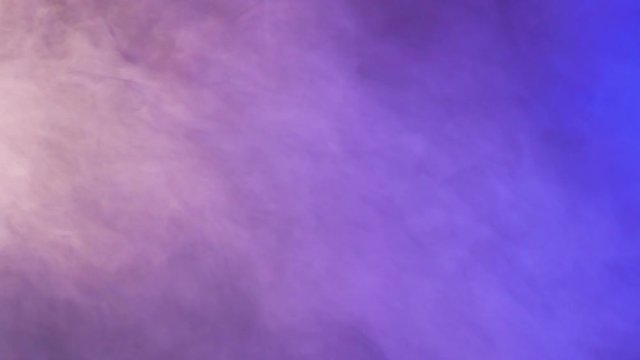 Colorful abstract purple and blue smoke over a black background in studio. 4K footage