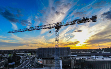 Crane construction tower with sun setting in the background