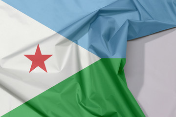 Djibouti fabric flag crepe and crease with white space, a horizontal light blue and light green with a white triangle at the hoist bearing a red star.