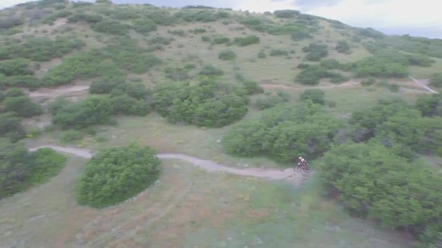 Drone view of a mountin biker going downhill a mountain in Colorado