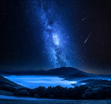 Fototapeta Milky way and falling stars over mountains, Castelluccio, Umbria, Italy
