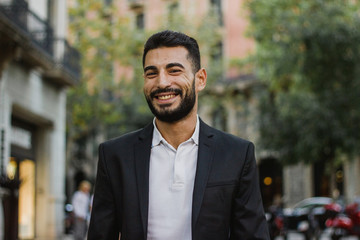 Handsome arabic guy smiling. Successful man walking on the street