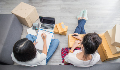 Start up small business entrepreneur SME, asian woman writing on clipboard box. Portrait of young Asian small business owner home office, online marketing packing delivery team, SME e-commerce concept