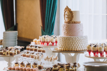 Candy bar with a lot of cookies and fruits during the wedding. chocolate fountain and wedding cake. Coktails and drink at the table