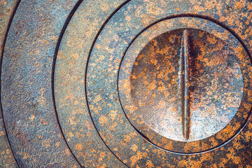 Fototapeta na wymiar Abstract metal background with geometric holes in a circle and rust texture orange-brown with spots. Selective focus