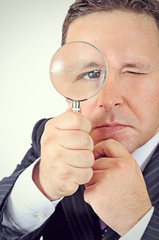 businessman in a suit looking through a magnifying glass