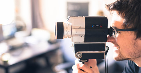 Junger Mann dreht mit Vintage/Retro-Kamera einen Film für ein Filmfestival, Breitbild