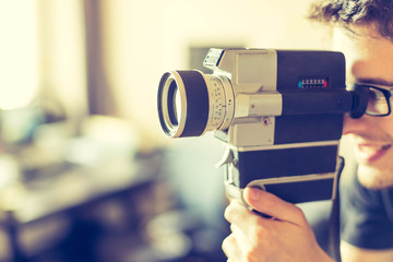 Junger Mann dreht mit Vintage/Retro-Kamera einen Film für ein Filmfestival 