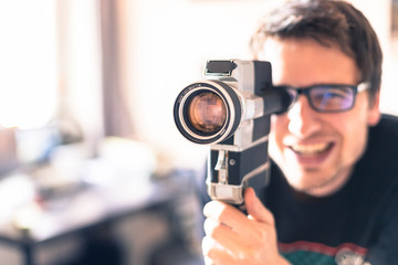 Junger Mann dreht mit Vintage/Retro-Kamera einen Film für ein Filmfestival 