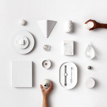 White design items flatlay and hands with different skin colors coming in