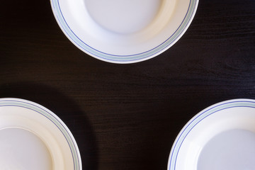Empty Plates on Black Wooden Background