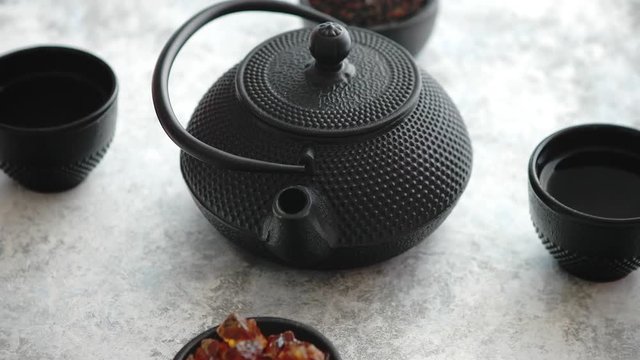 Traditional eastern metal teapot and iron cups with mint tea leafs over the white rusty stone background
