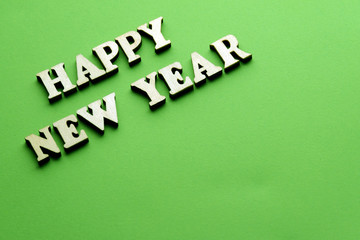 Obraz premium Woden letters new year on the green background.
