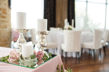 wedding banquet table served and decorated with fresh flowers and white candles. Wedding decoration concept