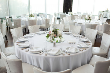 wedding banquet table served and decorated with fresh flowers and white candles. Wedding decoration concept