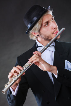 Elegantly dressed male musician playing flute