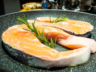 steaks of salmon, in a pan, with rosemary,