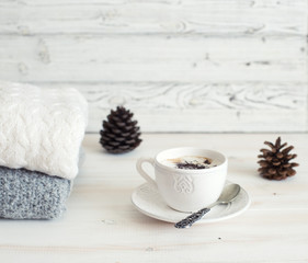 Winter still life with wool clothes, cup of coffee and pine cones