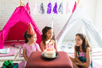 Girls Wearing Party Hats With Birthday Cake On Table © AntonioDiaz