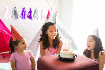Girl Making A Wish While Friends Celebrating Her Birthday © AntonioDiaz