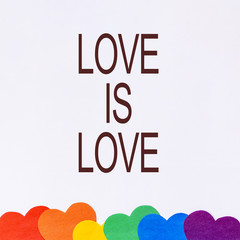LGBT day concept, six paper hearts of rainbow color like LGBT flag with text love is love on white background