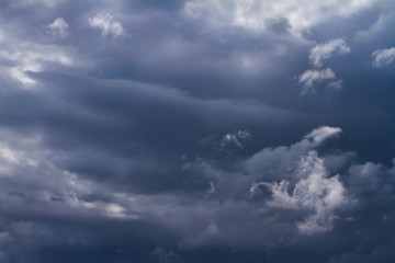 Obraz premium Group of flying dark storm clouds formed before hard raining and thunderstorm background. Beautiful Moody sky picture.