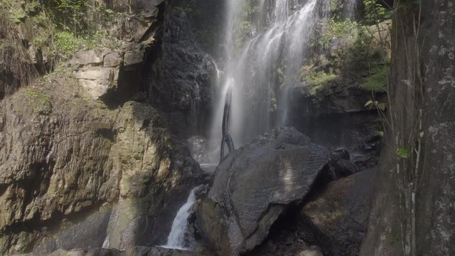 Wide shot of people taking shower at Jeram Pelangi waterfall in Maran, Malaysia