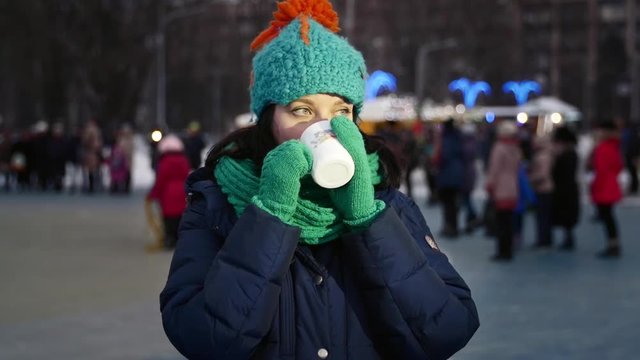 HD Close up shot Christmas time a girl is drinking tea with dancing children on background