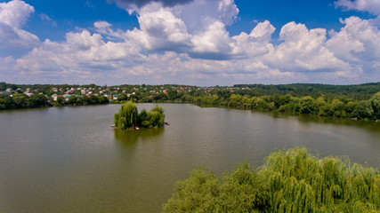 Aerial view of green trees in the center of the lake. Beautiful nature.