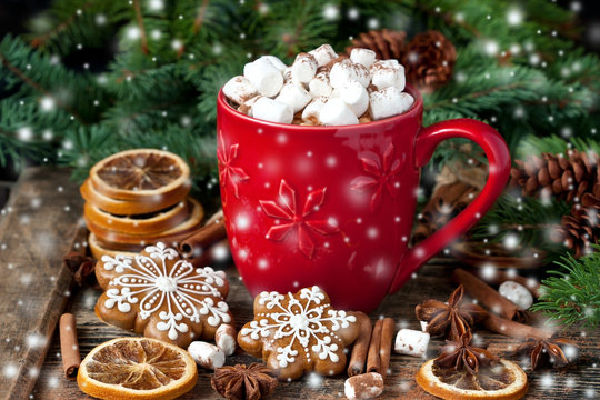 Mug filled with hot chocolate and marshmallows and gingerbread cookies