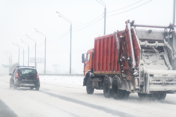 red garbage truck on winter road