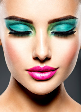 Beautiful Face of a woman with green vivid make-up of eyes