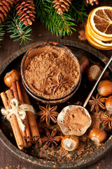 Cocoa powder and spices on wooden background