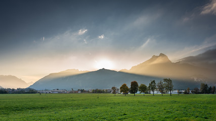 Mountainchain Hahnenkamm in Tyrol with sunbeams from behind the summit