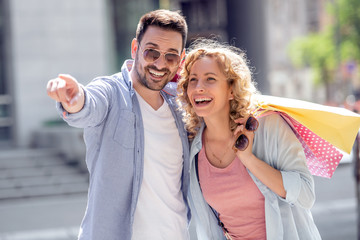 Cheerful couple shopping together in the city