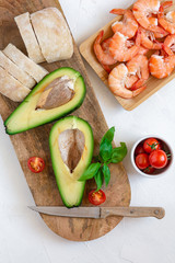 Ingredients for the preparation of bruschetta with shrimps and avocado.