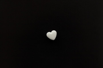 Heart shaped medical pills on te dark background