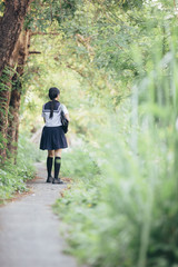 Fototapeta na wymiar Portrait of asian japanese school girl costume looking at park outdoor film vintage style