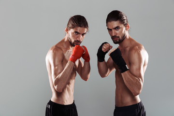 Fototapeta na wymiar Portrait of a two confident muscular shirtless twin brothers